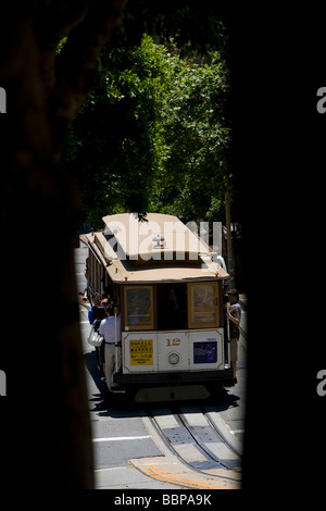 Ungewöhnliche Sicht durch Bäume einer Seilbahn absteigend Powell Street, San Francisco, Kalifornien. Stockfoto