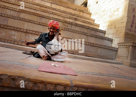 Ein Turban Straßenmusiker spielt ein traditionelles indisches Saiteninstrument in Jaisalmer Fort in Rajasthan in Indien Stockfoto