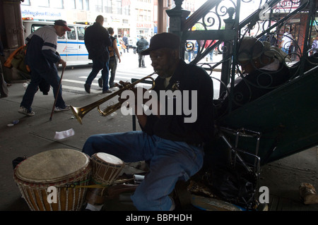 Ein Straßenmusikant spielt die Trompete unter den Bahngleisen der Metro North in harlem Stockfoto