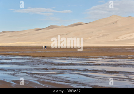 Colorado San Luis Tal Great Sand Dunes National Park zu bewahren paar überqueren Medano Creek, auf Dünen wandern Stockfoto