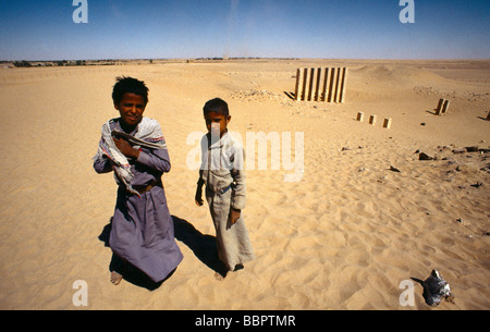 MA'rib Jemen Lokale Jungen an den Resten des Großen Tempels von Marib (der Tempel von Awwan) zeigt die acht Säulen des Propylaeums Stockfoto