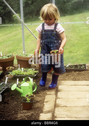 Kleinkind im Gewächshaus mit Blumentöpfen Stockfoto