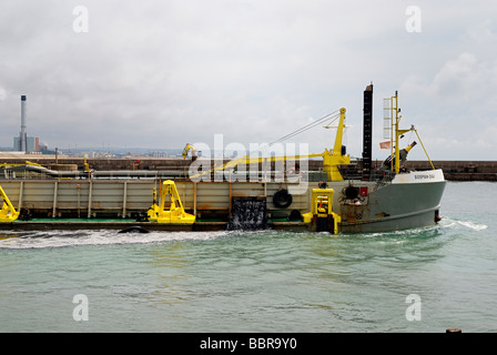 Ein Bagger Baggern die Einfahrt in einen Hafen Stockfoto