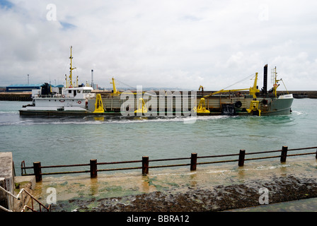 Ein Bagger Baggern die Einfahrt in einen Hafen Stockfoto