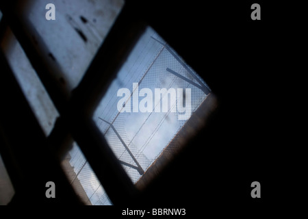 Blick durch ein Fenster in Alcatraz Gefängnis zeigt ein Loch in den Zaun, der den Gefängnis Zellenblock umgibt. Stockfoto