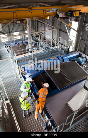 Drei Menschen tragen Sicherheit Kleidung Inspektion zerkleinern Maschinen in Kalkstein Steinbruch in der Nähe der Cardiff Wales UK Stockfoto