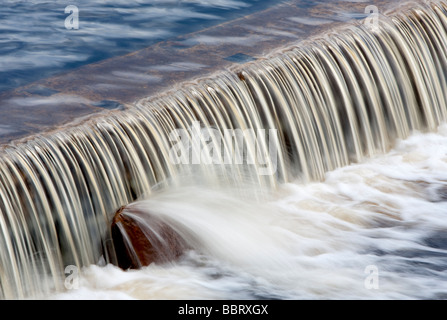 Wasser fließt über den untergetauchten Staudamm Stockfoto