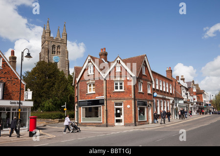 St. Mildred's Parish Church Uhrenturm hinter Geschäften auf der High Street in der historischen Stadt Wealden. Tenterden Kent England Großbritannien Stockfoto