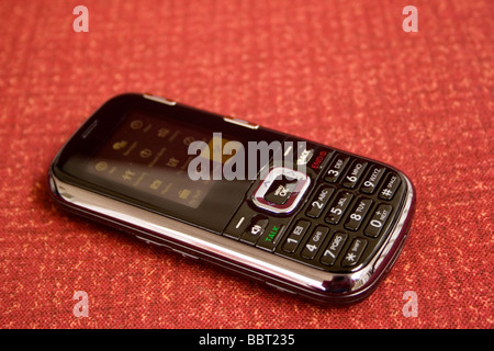 Ein Handy sitzt auf einem orangefarbenen Hintergrund Stockfoto