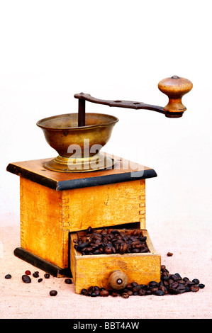 Antike Kaffeemühle mit Kaffeebohnen Stockfoto