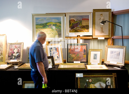 Ein Mann Einkaufen für Kunst auf einer Antiquitätenmesse in Newmarket, Großbritannien Stockfoto