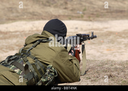 Terrorist gekleidete Mann in eine Sturmhaube feuern eine AK47 Kalaschnikow und tragen eines Gürtels von Kugeln Stockfoto