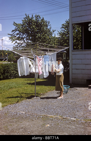 Eine Frau hängt Wäsche auf eine neuartige Kleidung trockener 1957 Stockfoto