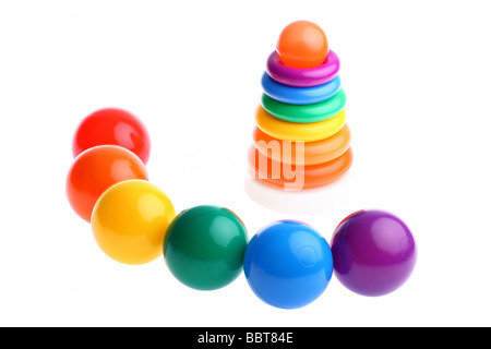 Sechs glänzend gefärbt Spielzeug aus Plastik Kugeln mit mehrfarbigem Stapeln Ringe Spielzeug auf weiß isoliert. Textfreiraum verfügbar Stockfoto
