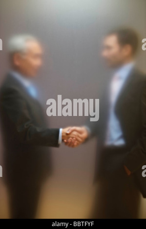 Männer Händeschütteln hinter Matt Leinwand Stockfoto