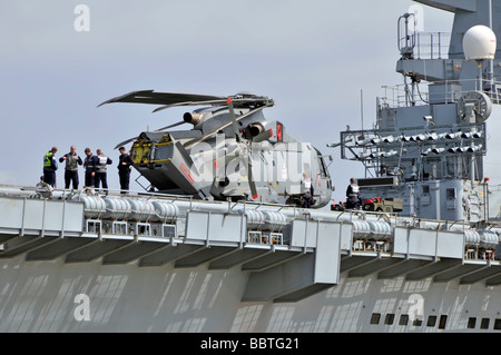 Hubschrauber wird über Deck des Flugzeugträgers HMS Illustrious Licht manövrieren Stockfoto