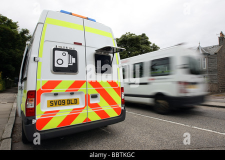 Ein Safety Camera van geparkt an der Seite einer Straße in Aberdeen, Schottland, Vereinigtes Königreich, mit einem unscharfen Kleinbus fahren durch Stockfoto