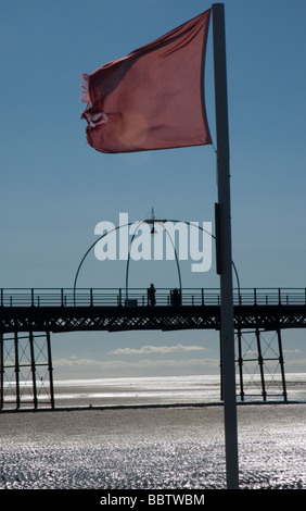 Eine rote Fahne fliegt am Strand von Southport, Merseyside, nahe dem pier Stockfoto