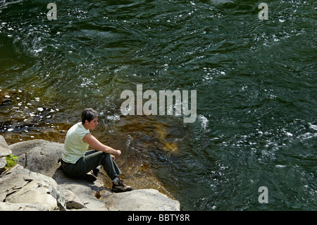 Frau sitzt auf Felsen neben dem Flüsschen in der Great-Smoky-Mountains-Nationalpark-Tennessee Stockfoto