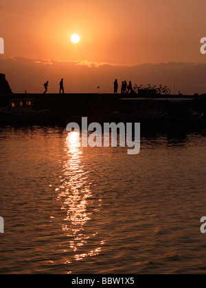 Spaziergänger, die Silhouette auf der Oberseite der Hafenmauer in Heraklion Kreta Griechenland Stockfoto