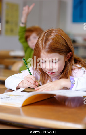 Kinder in einem Klassenzimmer in Grundschule, Mädchen suchen, clever, schlau und sachkundig, gleich Oppurtunity in der Bildung-sy Stockfoto