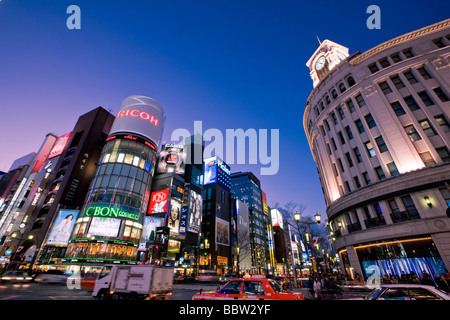 Fahrzeuge mit beleuchteten Gebäuden in der Nacht unterwegs Stockfoto