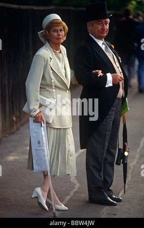 Mann und Frau Paar in formalen Rennen-Gänger Kleid warten auf Transport nach Hause nach Ladies' Day in Royal Ascot Stockfoto