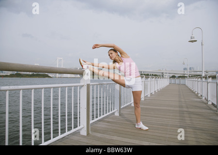 Young Woman stretching Beine auf Brücke Stockfoto
