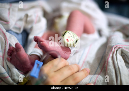 Neugeborenen jungen Bein ausgestattet mit "Baby Lojak", ein Sensor, der ertönt, wenn das Baby einen sicheren Bereich verlässt Stockfoto