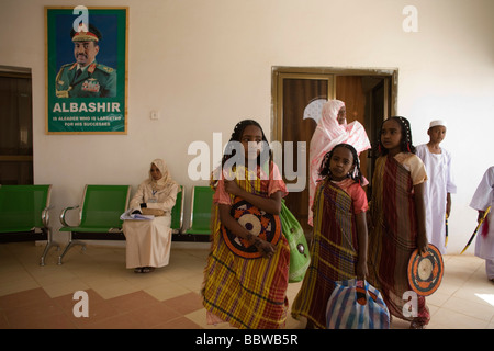 Darfurs Kinder warten unter imposanten Porträt des sudanesischen Präsidenten Omar Hassan Ahmad al-Baschir Al Fashir Flughafen Stockfoto