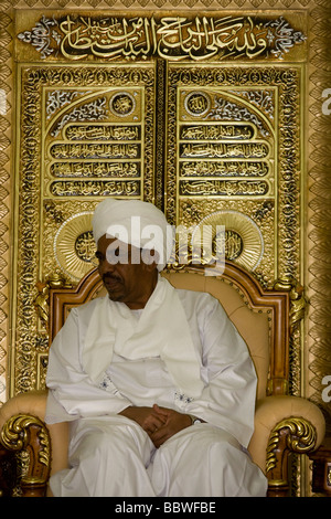 Sudanesischen Präsidenten Omar Hassan Ahmad al-Bashir sitzen gegen Blattgold islamischer Texte in einem Empfangssaal seines Palastes Stockfoto