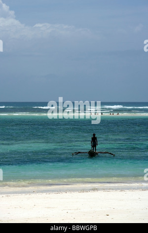 Mann stand am Ausleger-Kanu - Diani Beach - in der Nähe von Mombasa, Kenia Stockfoto