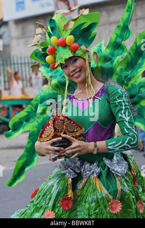 Frau mit Sinulog Kostüm und eine Santo Niño-Puppe Stockfoto