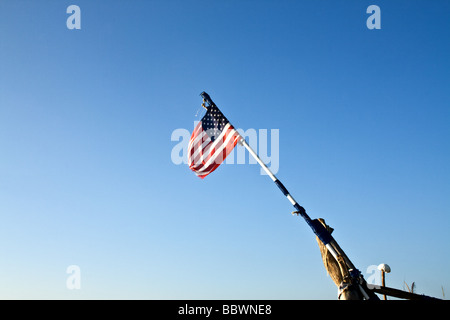 Alten zerrissenen amerikanische Flagge auf einem provisorischen Mast auf ein strahlend blauer Himmel Stockfoto