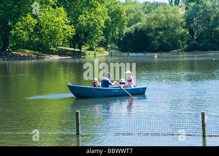 London, Regents Park, Familie, Vater, Mutter & zwei Tochter in blauen Ruderboot am See in der Frühlingssonne Stockfoto