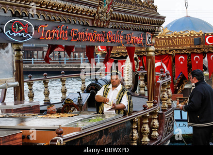 Türke im traditionellen Kostüm Vorbereitung Fischbrötchen auf einem historisch eingerichteten Boot, Goldenes Horn, Eminoenue, Istanbul, Türkei Stockfoto