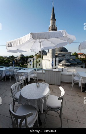 Tisch und Sonne Schatten auf der Dachterrasse eines kleinen Hotels in Sultanahmet, Blick auf Firuz Aga-Moschee und die blaue Moschee, Istanbul, Tu Stockfoto