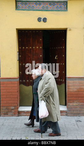 älteres Ehepaar Fuß die Straße hinunter in Sevilla Andalucia Spanien Stockfoto