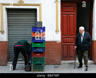 älterer Mann Uhren jungen Mann behandeln leere Kisten in Sevilla Andalucia Spanien Stockfoto