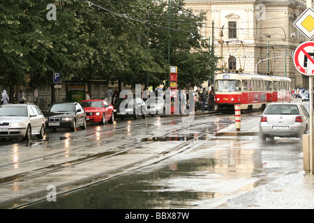 Prag, Straße im historischen Zentrum an einem regnerischen Tag. An der Straßenbahnhaltestelle befindet sich eine traditionelle Tram T3. Autos sind in einem Stau gesäumt. Stockfoto