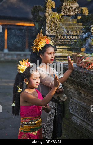 Junge Frau Kind bringen Opfergaben, Tempel, Ubud Bali Indonesien Modelle veröffentlicht Stockfoto