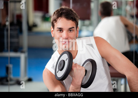 Porträt des jungen Mannes tun Gewichtheben im Fitness-Studio Stockfoto