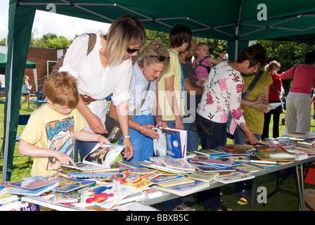 Besucher durchlesen Bücherstand an einer Schule Sommer fete, Medstead, Alton, Hampshire, UK. Stockfoto