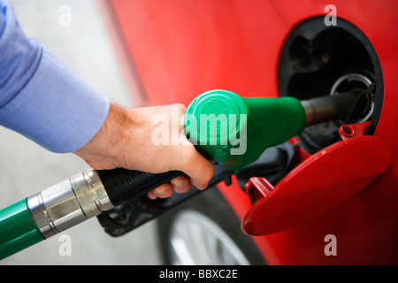 Ein Mann immer Benzin in seinem roten Auto Schweden. Stockfoto