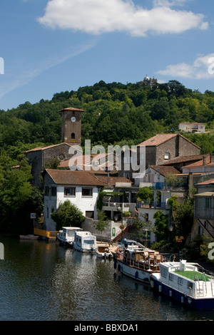 Französische Stadt in der Menge Tal Penne d'Agenais mit Liegeplätzen für Sportboote und Haus Boote Hang mit Kirche an der Spitze Stockfoto