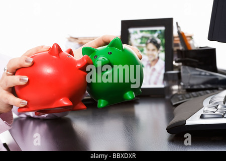 Geschäftsfrau Holding zwei Sparschweine. Stockfoto