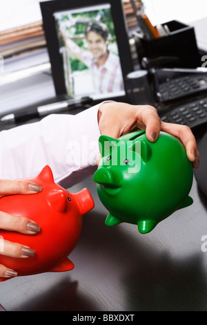 Geschäftsfrau Holding zwei Sparschweine. Stockfoto