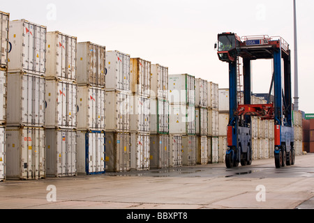 Ein Straddle Carrier LKW bewegt sich ISO-Container um den Container terminal gestapelt und verarbeitet werden. Stockfoto