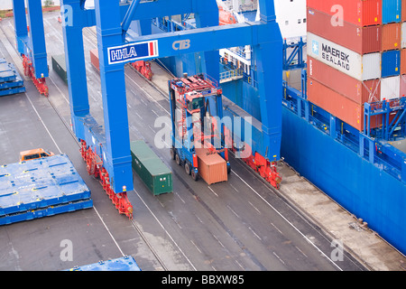 Ein Straddle Carrier LKW zieht ISO-Container vom Hafen Terminals weiter in Container-terminal. Stockfoto