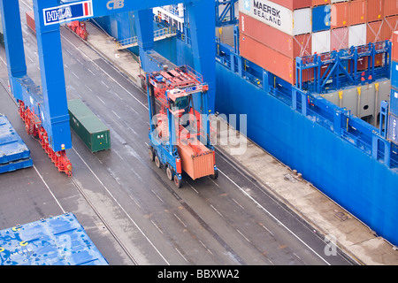 Ein Straddle Carrier LKW zieht ISO-Container vom Hafen Terminals weiter in Container-terminal. Stockfoto